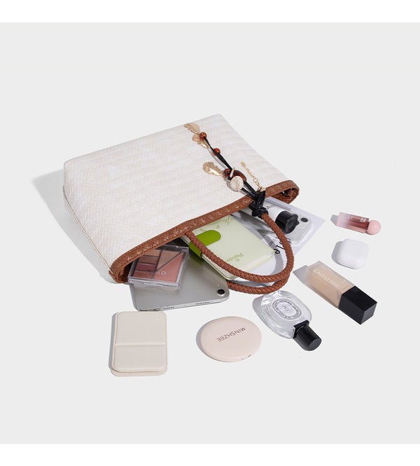 Structured woven-texture tote bag with brown braided top handles, decorative tassel charm, and detachable shoulder strap