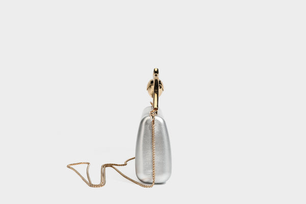 Strukturierte rechteckige Clutch mit goldfarbenem Henkel in Form einer Rosenknospe und abnehmbarem Kettenriemen in Metallic-Optik, Detailansicht
