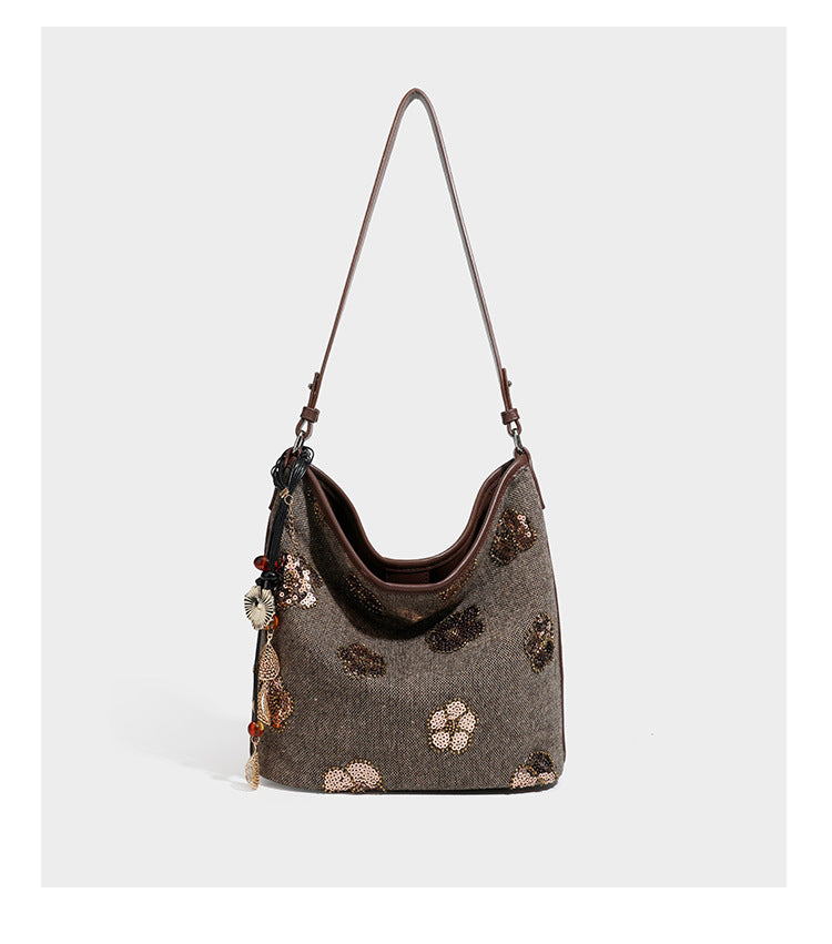 Lässig fallende Hobo-Schultertasche aus anthrazitfarbenem Webstoff mit floraler Stickerei aus silberfarbenen Pailletten, schwarzem Besatz in Lederoptik und langem