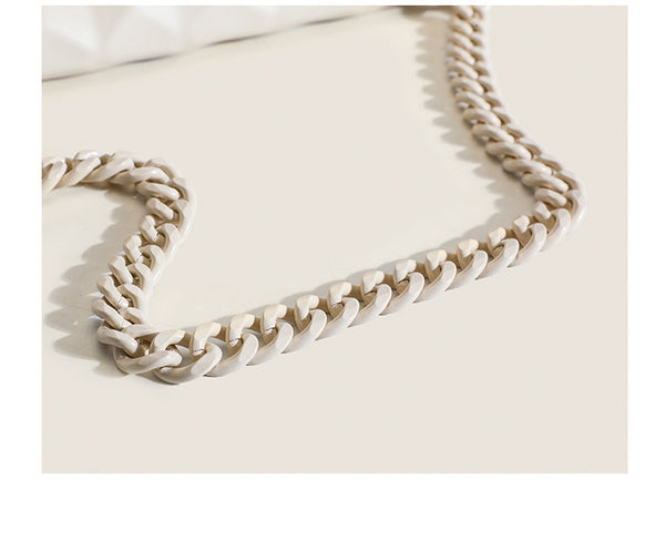 Cream white rectangular flap shoulder bag with geometric faceted surface and chunky tone-on-tone chain strap with gold-tone
