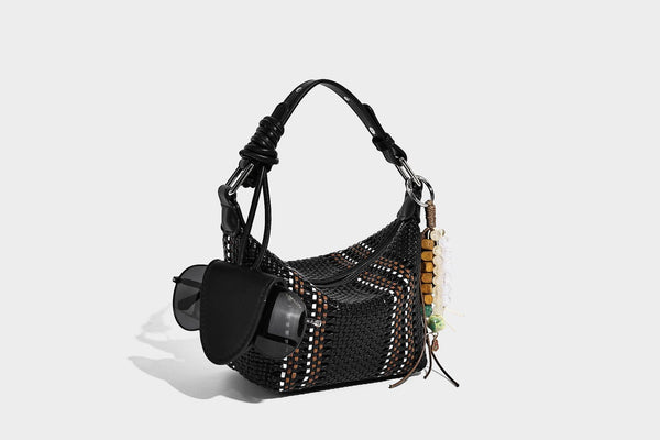 Small woven crescent shoulder bag with leather-look trim, zip closure, silver-tone ring hardware, and beaded tassel charm