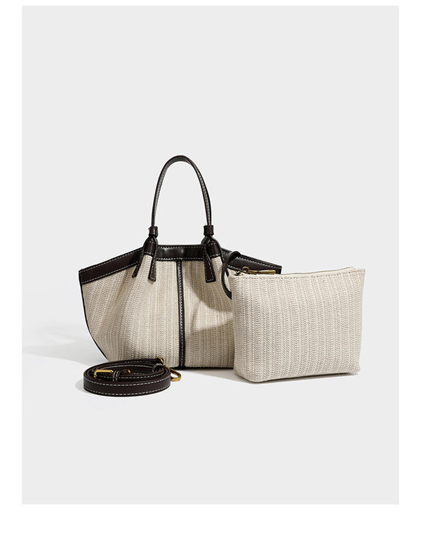 Cremefarbene geflochtene Tote-Bag mit dunkelbraunen Besätzen in Lederoptik, kontrastierenden weißen Nähten, zwei oberen Henkeln und abnehmbarem Schulter