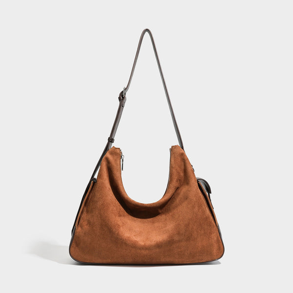 Cognac brown suede-look slouchy shoulder bag with dark brown leather-look trim, top zip closure, exterior side pocket, and