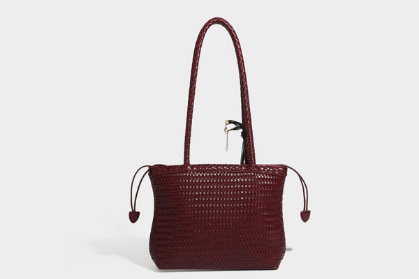 Structured woven leather-look tote bag in dark brown with long shoulder straps, side drawstring ties, and gold filigree
