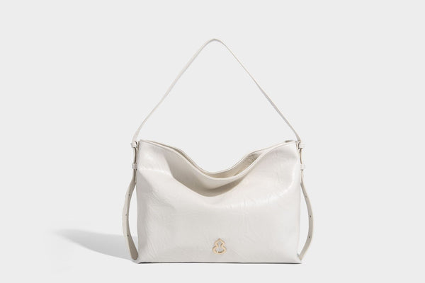 Large slouchy hobo shoulder bag in glossy crinkle leather-look finish with gold-tone emblem hardware and adjustable strap