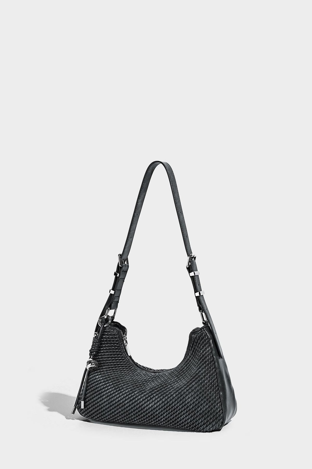 Woven crescent hobo shoulder bag with smooth side panels, zip-top closure, silver-tone charm hardware, and adjustable, detail