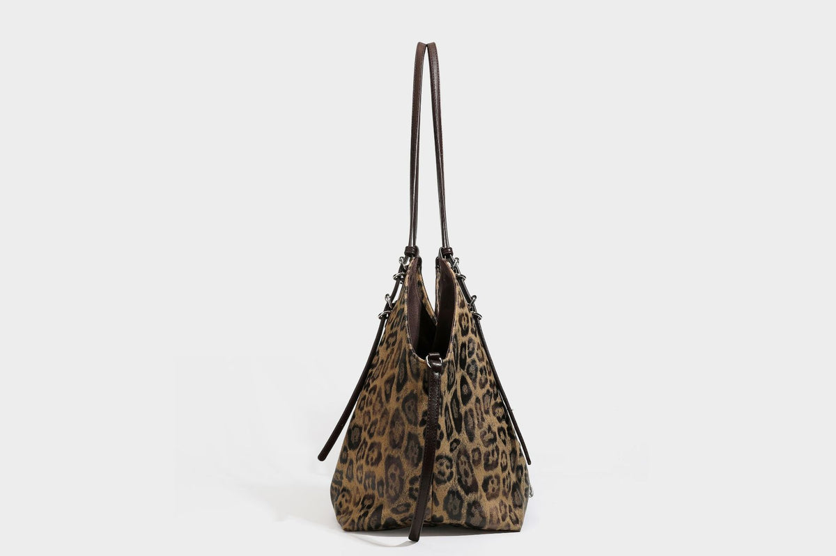 Slouchy leopard-print shoulder tote bag in tan and brown with long double straps, side tie straps, and dangling charm, detail