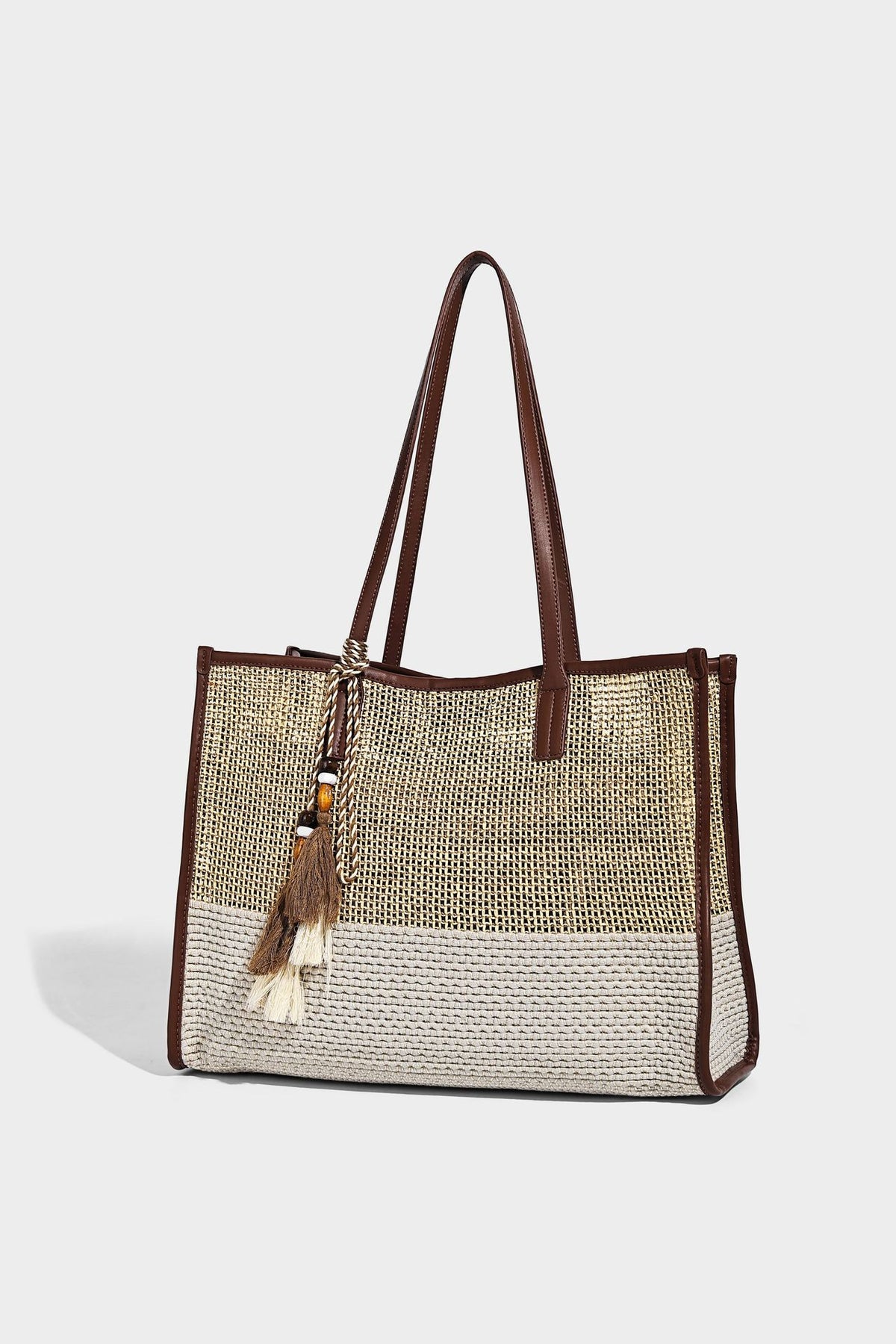 Große Tote-Bag aus grob geflochtenem Stroh in Beige und Creme mit dunkelbraunen Details in Lederoptik, langen Schulterriemen und einem mit Perlen verzierten