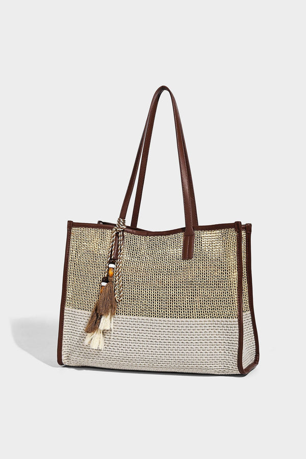 Große Tote-Bag aus grob geflochtenem Stroh in Beige und Creme mit dunkelbraunen Details in Lederoptik, langen Schulterriemen und einem mit Perlen verzierten