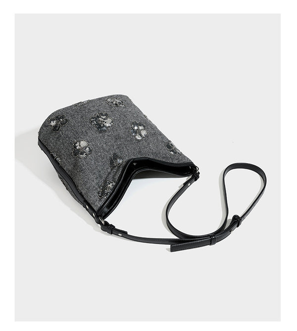 Lässig fallende Hobo-Schultertasche aus anthrazitfarbenem Webstoff mit floraler Stickerei aus silberfarbenen Pailletten, schwarzem Besatz in Lederoptik und langem