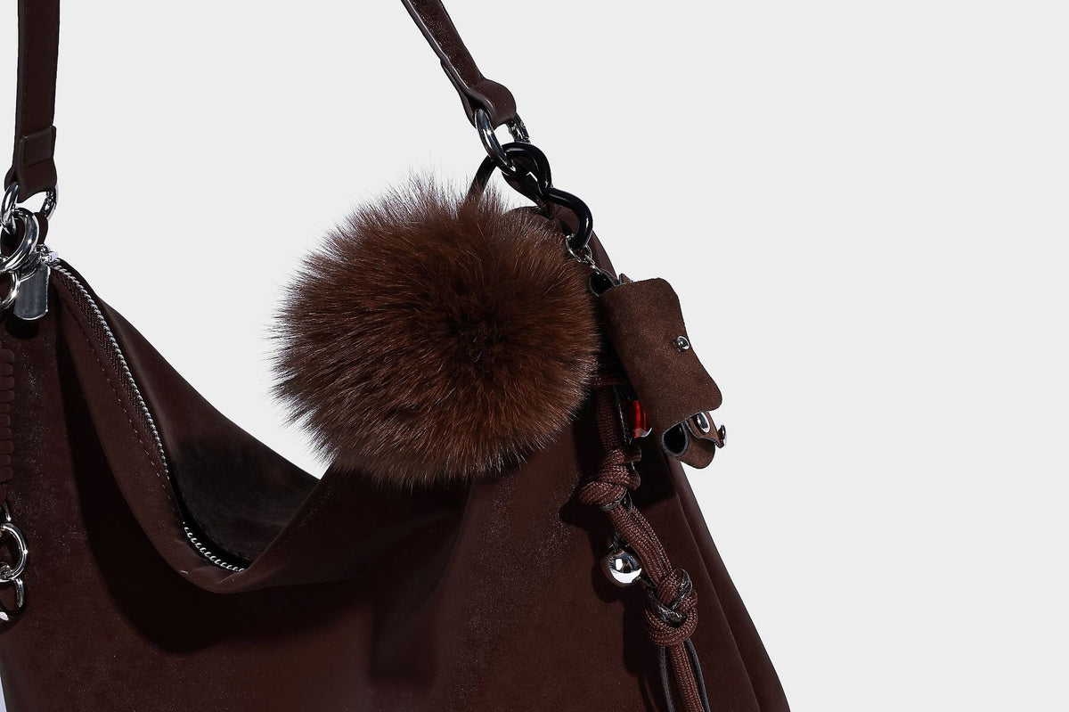 Slouchy matte-finish hobo shoulder bag with tassel cords, silver-tone hardware, and faux-fur pom charm, detail view 22