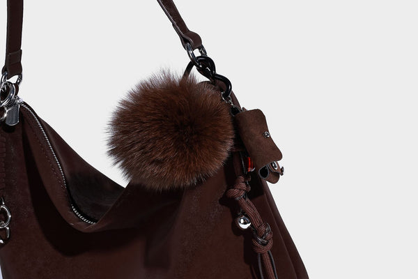 Slouchy matte-finish hobo shoulder bag with tassel cords, silver-tone hardware, and faux-fur pom charm, detail view 22