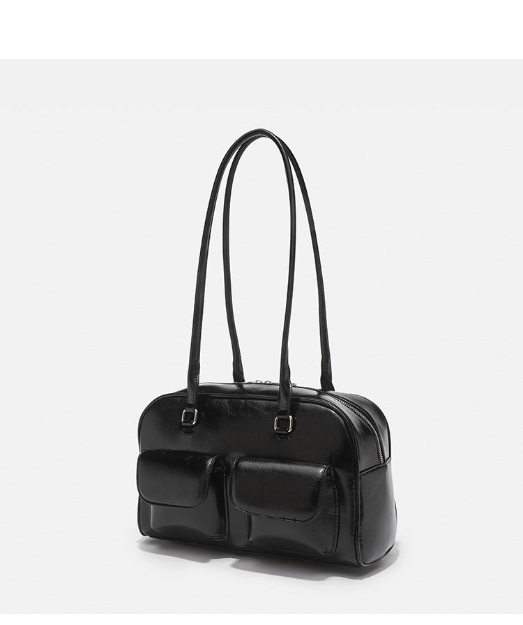 Structured glossy leather-look bowling shoulder bag with two front flap pockets, top zip closure, and long double shoulder