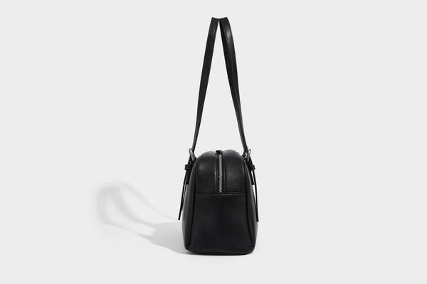 Structured dome-shaped shoulder bag with leather-look finish, top zipper closure, dual adjustable slim straps, and, detail