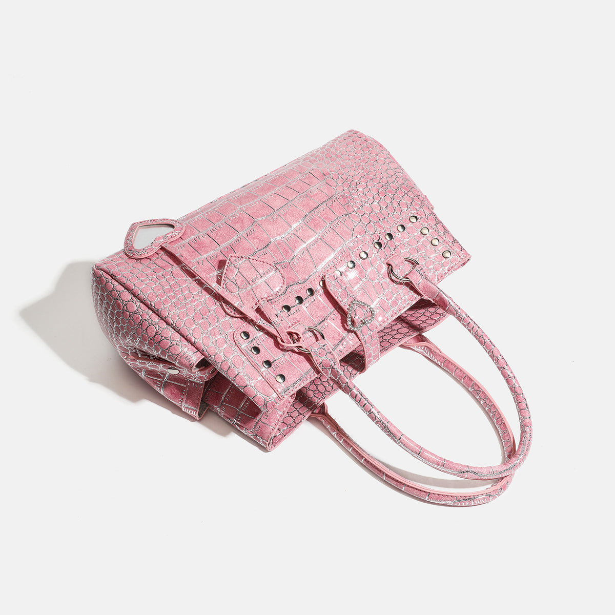 Blush pink glossy crocodile-embossed structured tote bag with studded trim, silver-tone hardware, double top handles, and