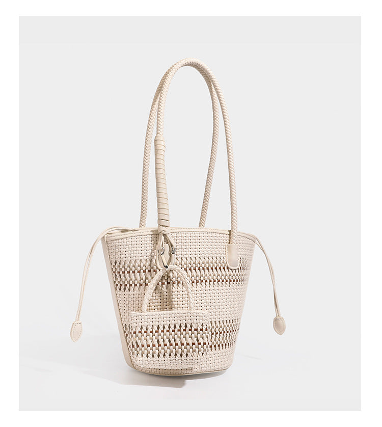 Structured woven bucket tote bag in pastel blue with braided shoulder strap, open lattice weave body, cream drawstring