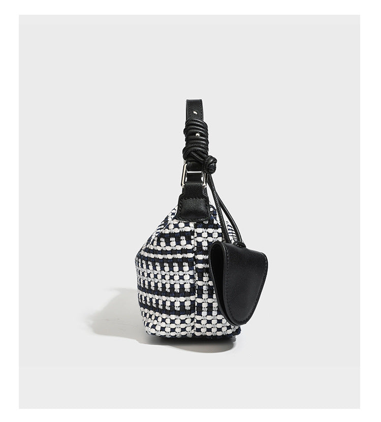 Small crescent shoulder bag in black-and-white woven textile with smooth black leather-look trim, zip-top closure, knotted