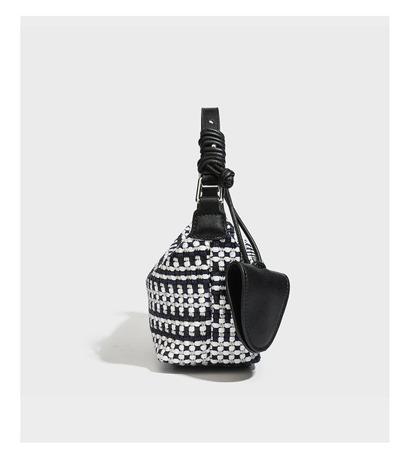 Small crescent shoulder bag in black-and-white woven textile with smooth black leather-look trim, zip-top closure, knotted