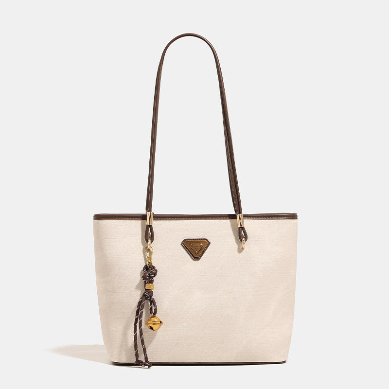 Großer strukturierter Shopper mit offenem Oberteil in Creme mit dunkelbraunen Besätzen in Lederoptik, zwei Schulterriemen und dreieckigem Logo-Badge