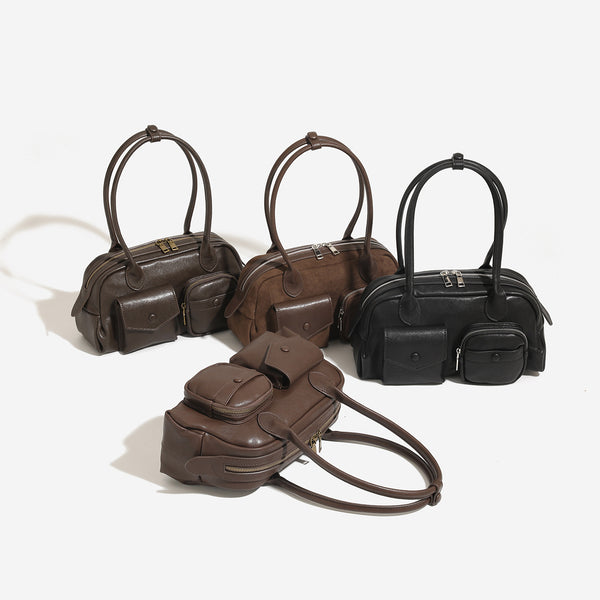 Structured matte leather-look bowling bag with snap-flap and zip front pockets, looped top handles, and antique gold-tone