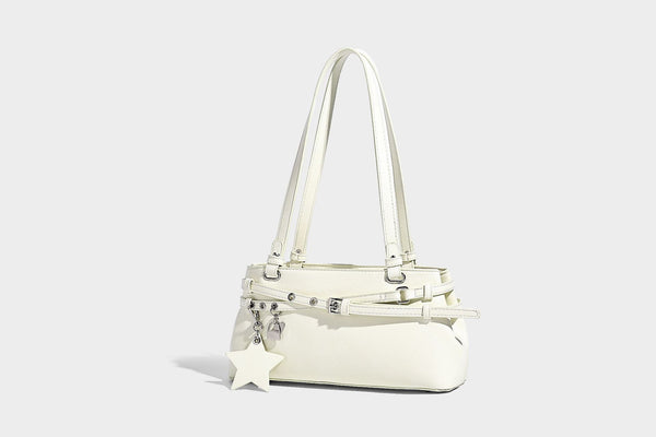 Structured glossy leather-look shoulder bag with wraparound belt straps, silver-tone hardware, and dangling star charm