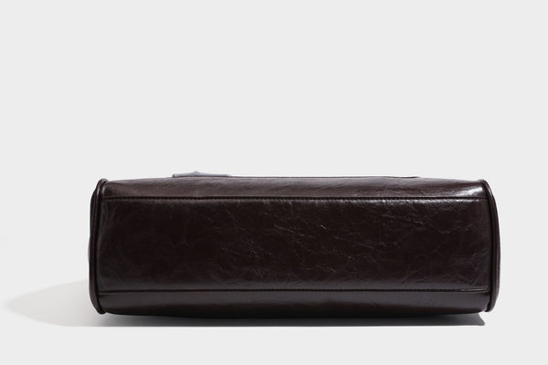 Structured glossy leather-look satchel bag with flap closure, gold-tone buckle accents, double top handles, detachable