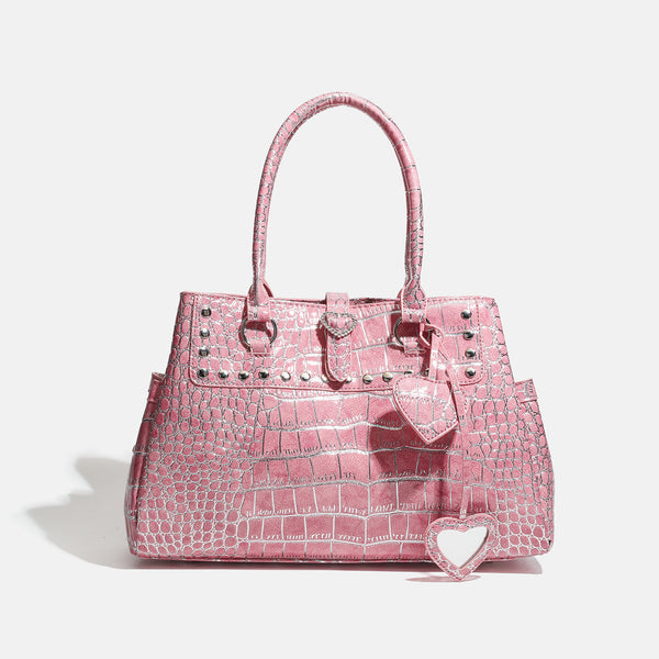 Blush pink glossy crocodile-embossed structured tote bag with studded trim, silver-tone hardware, double top handles, and
