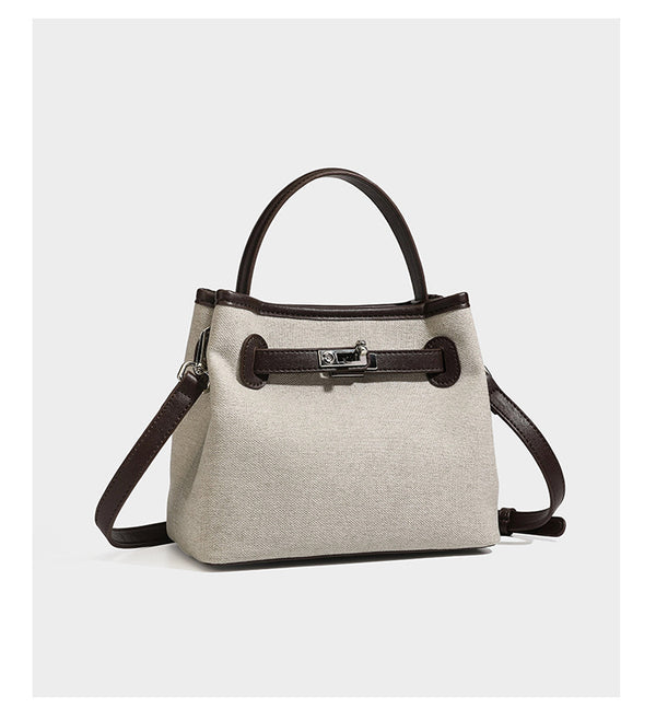 Small structured beige canvas top-handle bag with dark brown leather-look trim, silver turn-lock hardware, and detachable