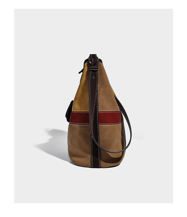 Lässig geschnittene Patchwork-Bucket-Bag mit dunkelbraunen, beigefarbenen, senfgelben, olivgrünen, roten und hellblauen Partien sowie kontrastfarbenen Nähten