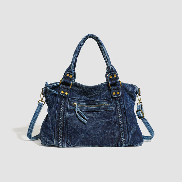 Large washed blue denim-look shoulder bag with gold-tone rings and rivets, top zip closure, front zip pocket, and adjustable