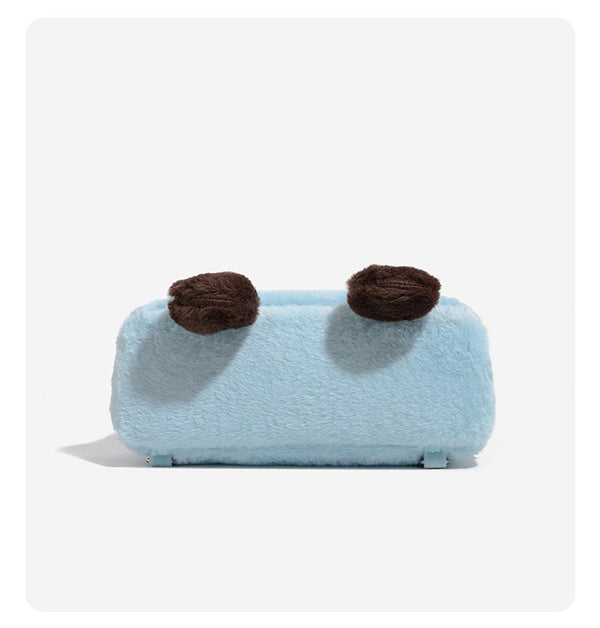 Ice-blue plush faux-fur Kelly-style convertible bag with embroidered smiling face, dark pom-pom feet, silver-tone clasp