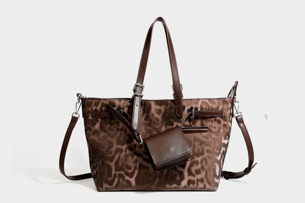 Glossy leopard-print tote bag with leather-look dark trim, dual top handles, detachable shoulder strap, and attached front