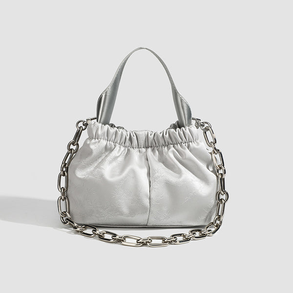 Small ruched satin-finish cloud bag with elasticized drawstring top, short top handle, and chunky silver-tone chain strap