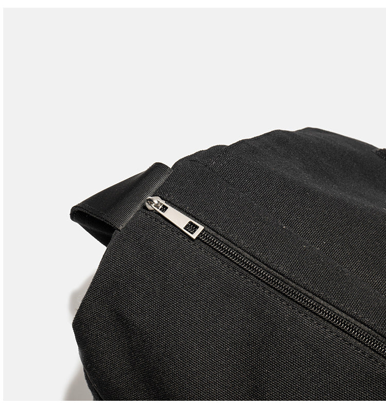 Große schwarze Messenger-Tasche aus mattem Canvas mit Überschlag vorn, Reißverschluss oben, elastischen Seitentaschen und verstellbarem silberfarbenem