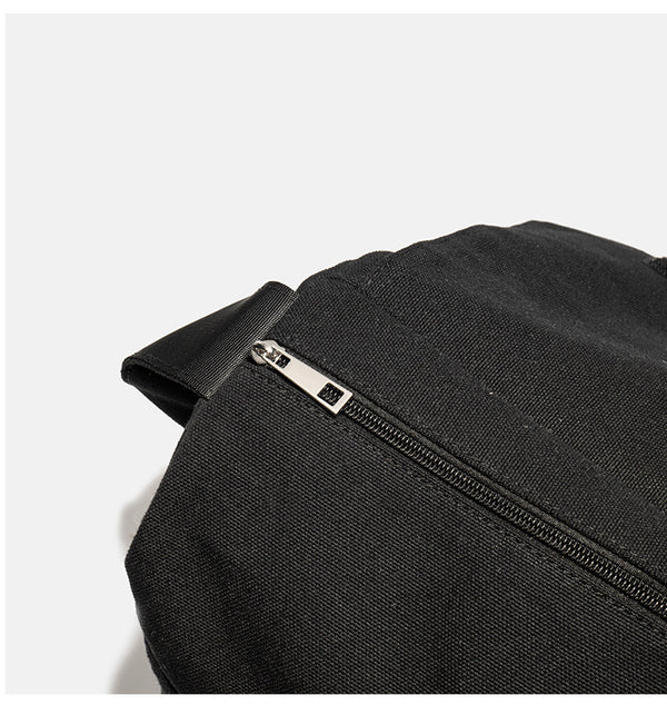 Große schwarze Messenger-Tasche aus mattem Canvas mit Überschlag vorn, Reißverschluss oben, elastischen Seitentaschen und verstellbarem silberfarbenem