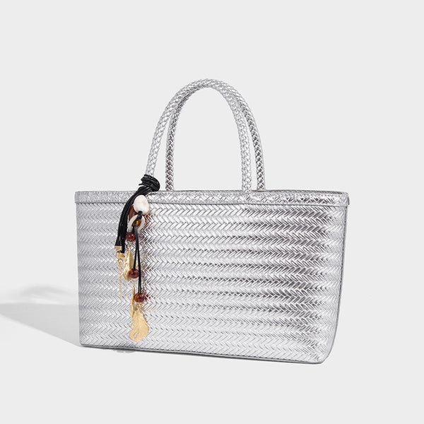 Structured woven-texture tote bag with brown braided top handles, decorative tassel charm, and detachable shoulder strap