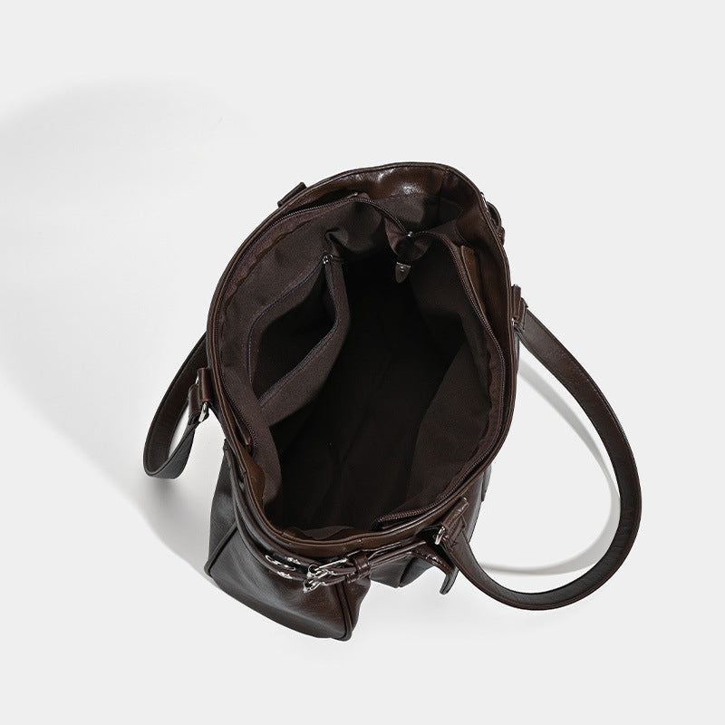Large glossy leather-look tote bag with front flap pocket, silver-tone buckle hardware, dual top handles and detachable