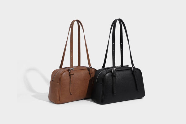 Structured dome-shaped shoulder bag with leather-look finish, top zipper closure, dual adjustable slim straps, and, detail