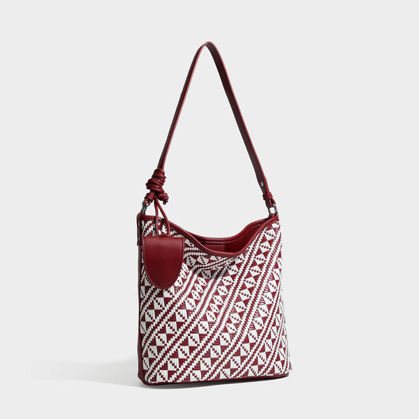 Geometrisch gemusterte Schultertasche mit gewebtem Ethno-Muster, dunkelbrauner Lederoptik-Besatzung, langem verstellbarem Riemen und kleinem herabhängendem Reißverschluss