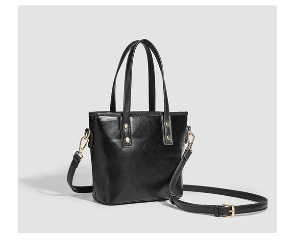 Kleine, formstabile Tote-Tasche mit Henkeln und Besatz in brauner Lederoptik auf einem cremefarbenen Korpus, Reißverschluss oben, goldfarbenen Nieten und