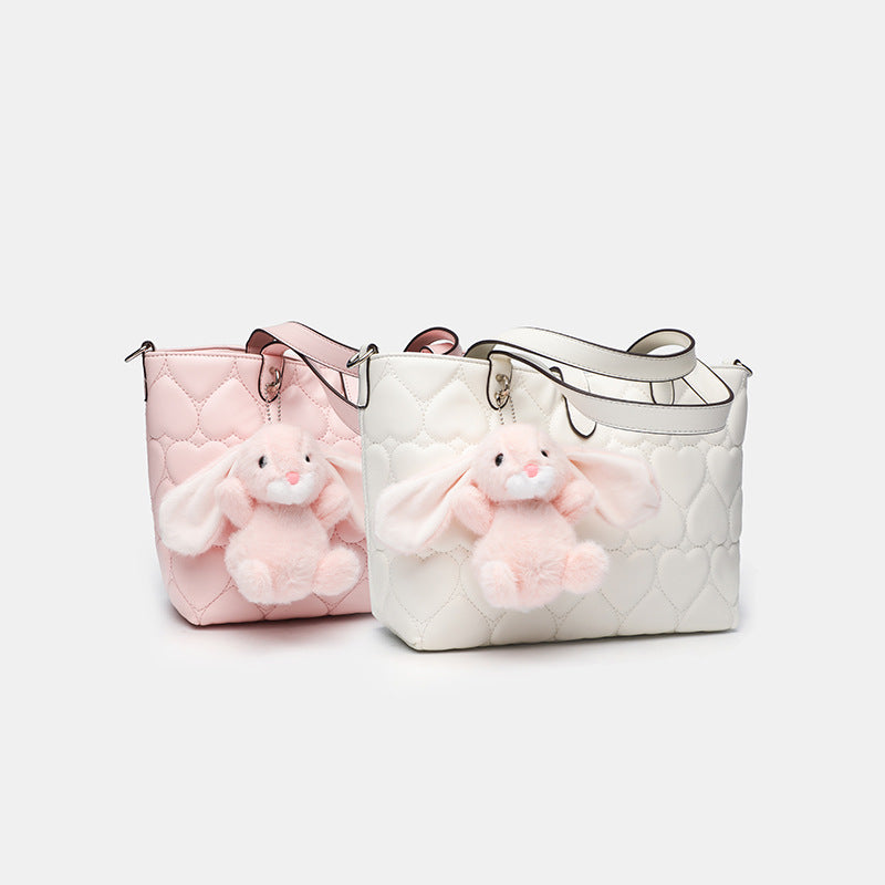 Heart-quilted leather-look tote bag with plush bunny charm, dual top handles, and detachable crossbody strap, detail view 2