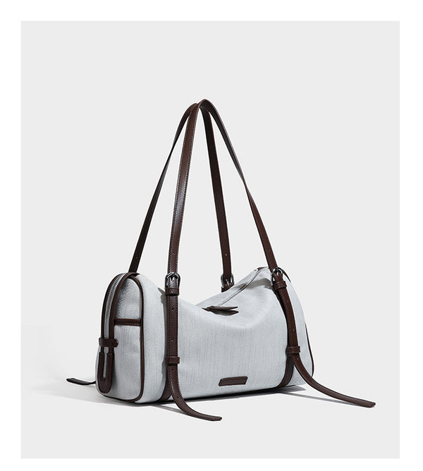 Olivgrüne Schultertasche in Zylinderform aus Canvas mit Riemen in schwarzer Lederoptik, Reißverschluss oben und silberfarbenen Beschlägen, Detailansicht
