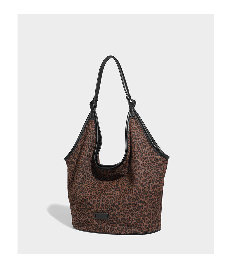 Slouchy brown leopard jacquard hobo tote bag with black leather-look trim and single shoulder strap, shown with black, detail