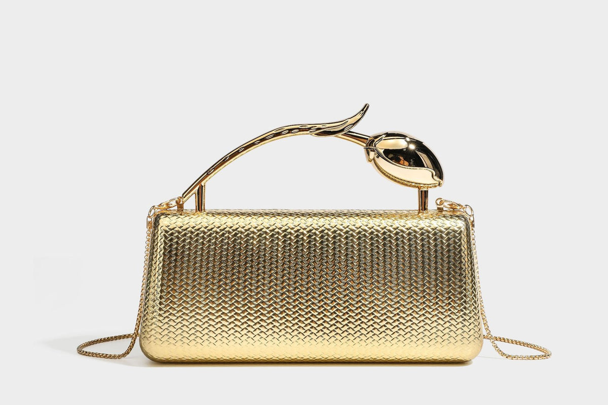 Structured rectangular metallic woven clutch bag with sculptural gold-tone leaf top handle and detachable chain strap, detail