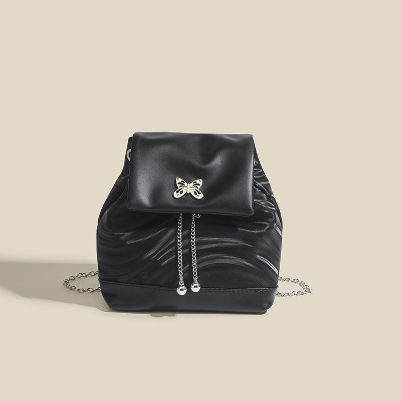 Compact ripple-embossed leather-look backpack handbag with silver butterfly clasp and chain straps, detail view 6
