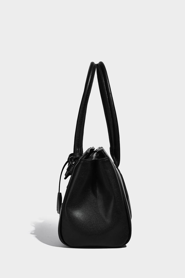 Strukturierte Tote-Bag in schwarzer Lederoptik mit Drehverschluss in Vorhängeschloss-Optik, dekorativen Riemendetails und abgerundeten Doppelhenkeln