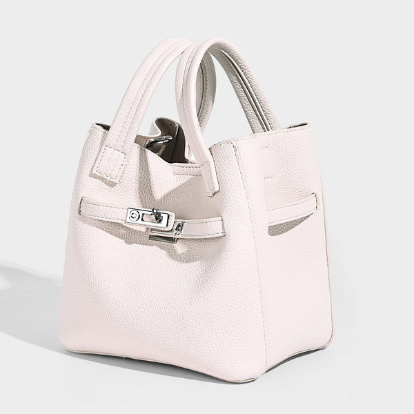 Small structured pebbled bucket tote bag with dual top handles, silver turn-lock front pocket, and detachable shoulder strap