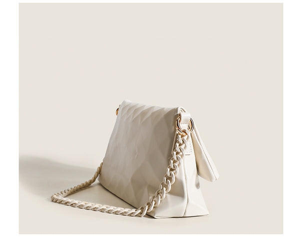 Cream white rectangular flap shoulder bag with geometric faceted surface and chunky tone-on-tone chain strap with gold-tone