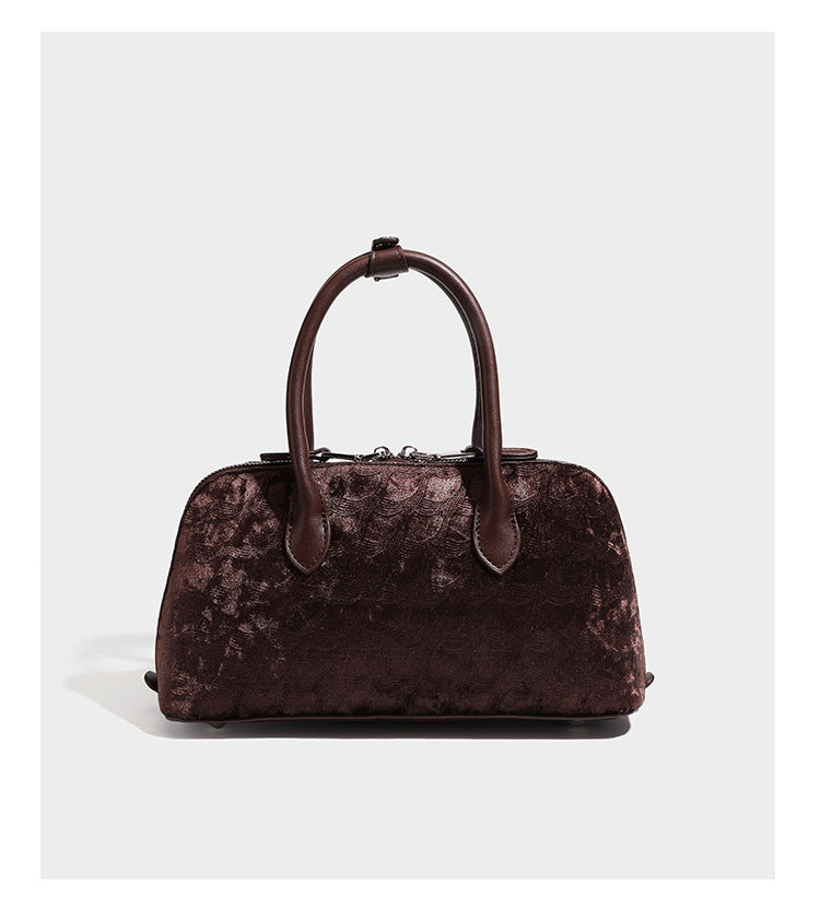 Small structured satchel bag in dark brown velvet-like textured finish with leather-look trim, silver-tone turn-lock bar
