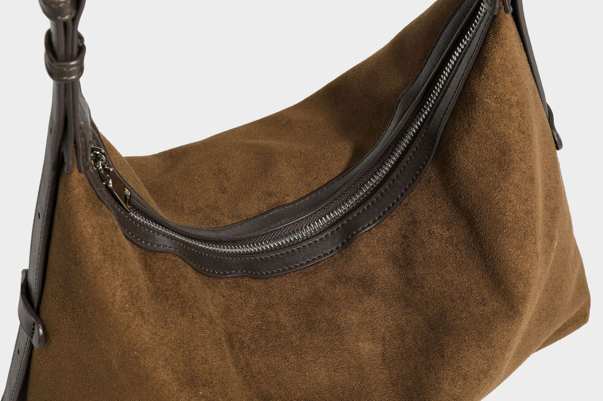 Lässige Hobo-Schultertasche mit matter brauner Wildlederoptik, dunklen glatten Besätzen, Reißverschluss oben und langem, verstellbarem